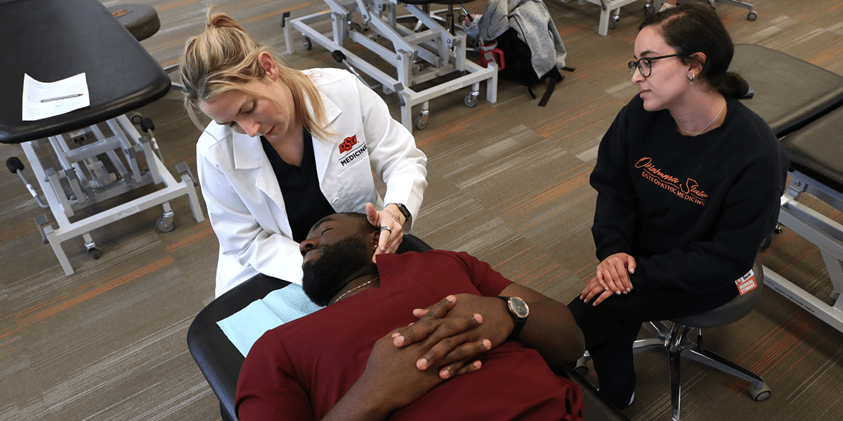 Facebook OMM Sports An osteopathic physician manipulates a patient athlete's neck as another watches on.