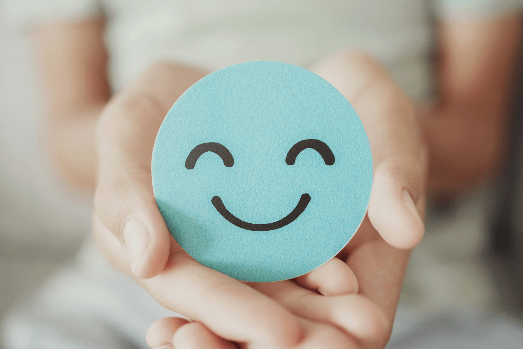 Mental Health 2024 Clasped hands hold a smiley face.
