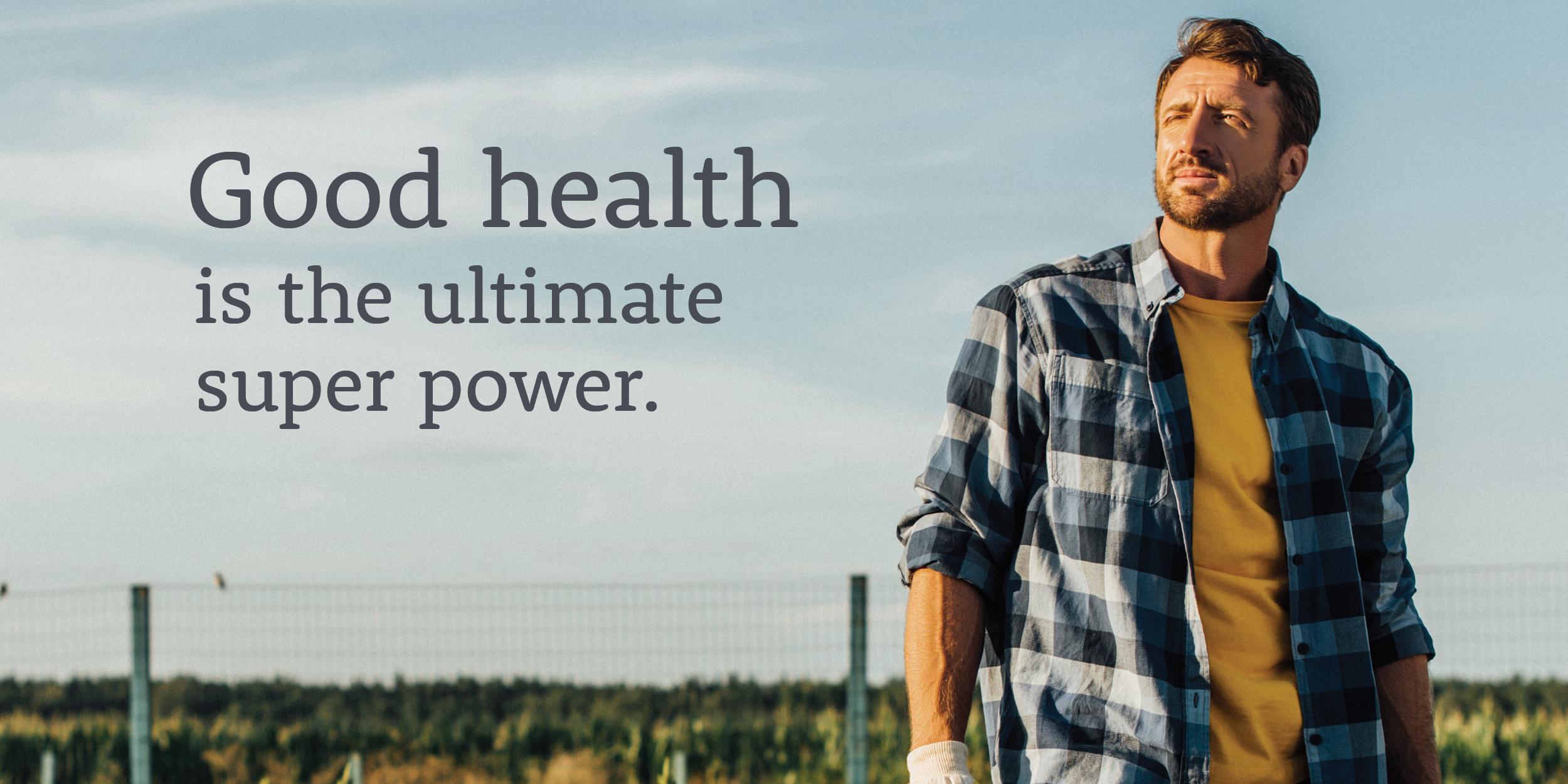 mens-health-social-1200×600 A man wearing a flannel shirt stands in the foreground with a fence and wide open sky in the background. A text overlay reads "Good health is the ultimate super power."