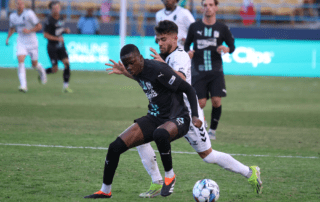 Two soccer players compete for control of the ball.