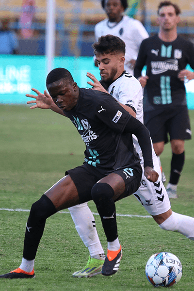 fc-tulsa-sm-v1 Two soccer players compete for control of the ball.
