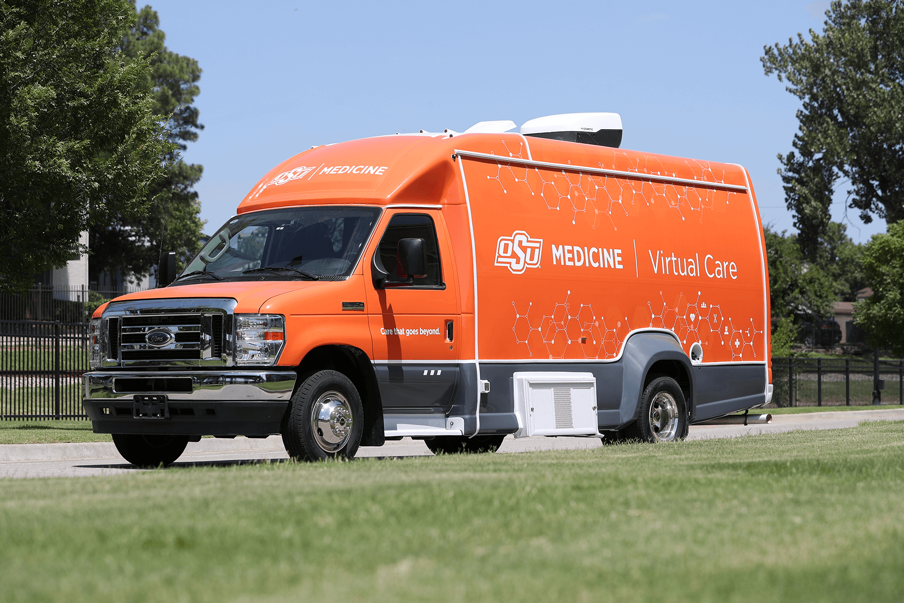 A large orange Ford OSU Medicine virtual care vehicle.
